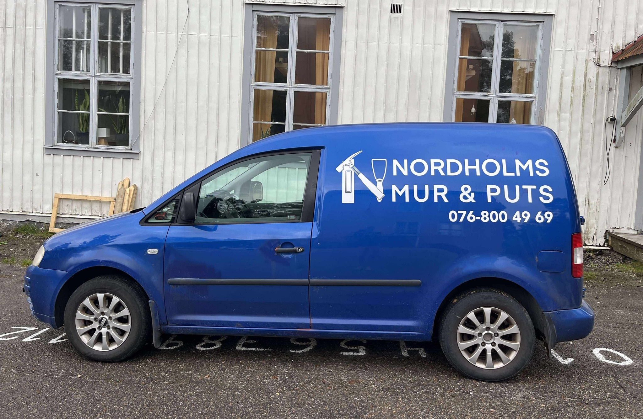 Murare som arbetar med putsning av fasad